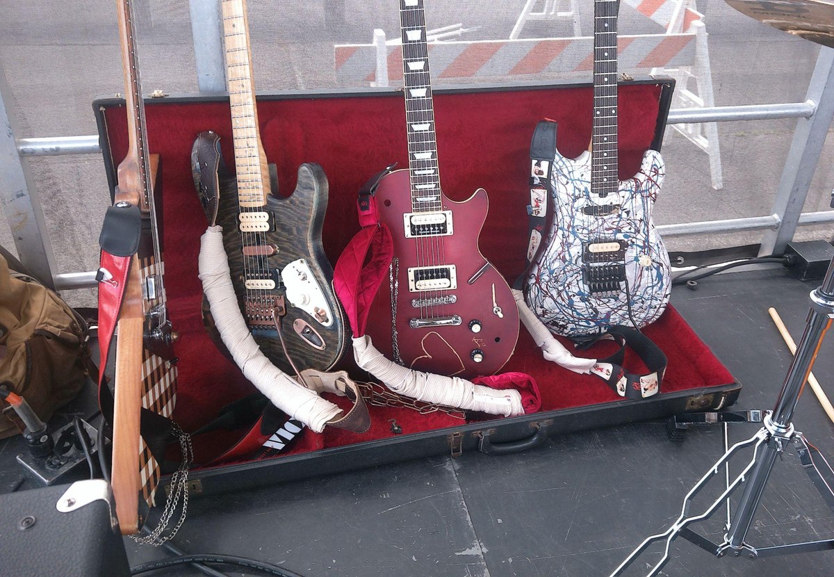 Three custom Stardust Six Strings builds in a red-lined case